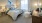 a bedroom with a bed, large window and a desk