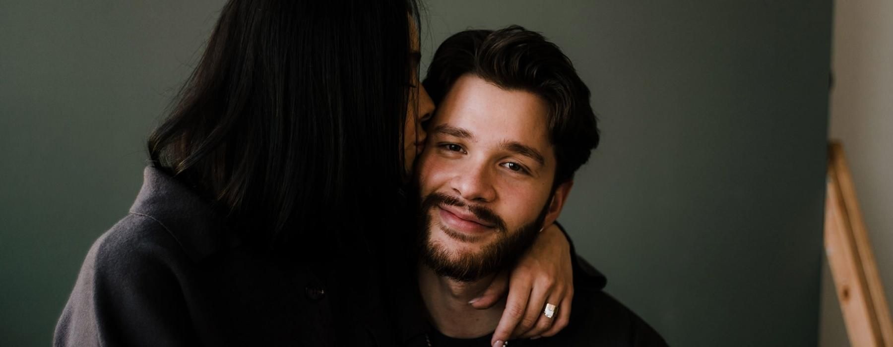 a woman kissing a man on the cheek