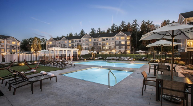 a pool with tables and chairs next to it