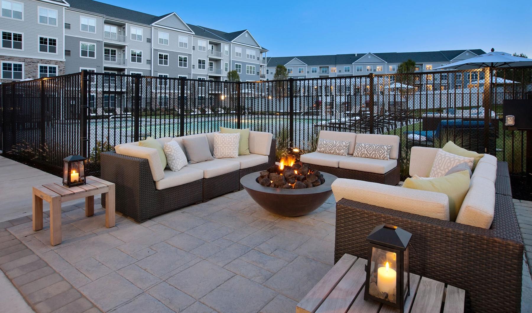 a patio with a fire pit near pool