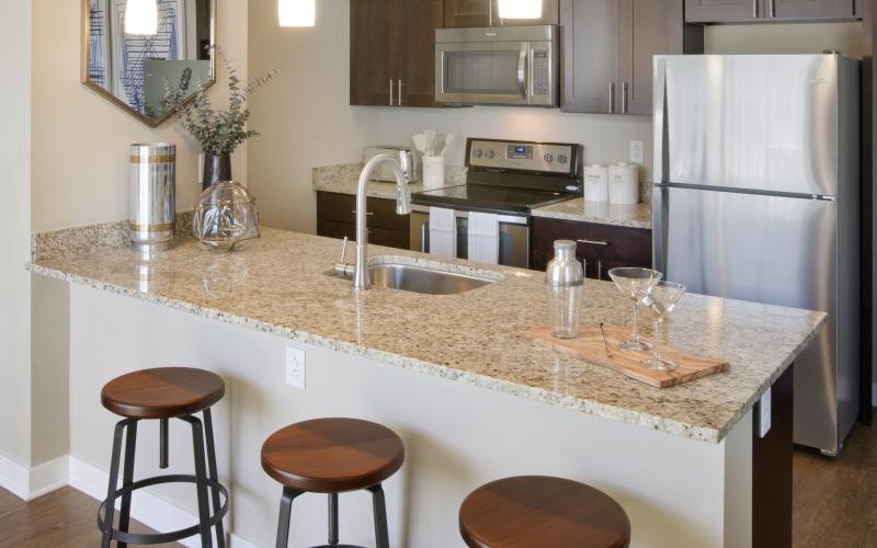 a kitchen with a marble island and stools
