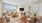 Large living room furnished with a couch, chair and view of dining table with chairs 