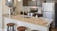 a kitchen with a marble island and stools