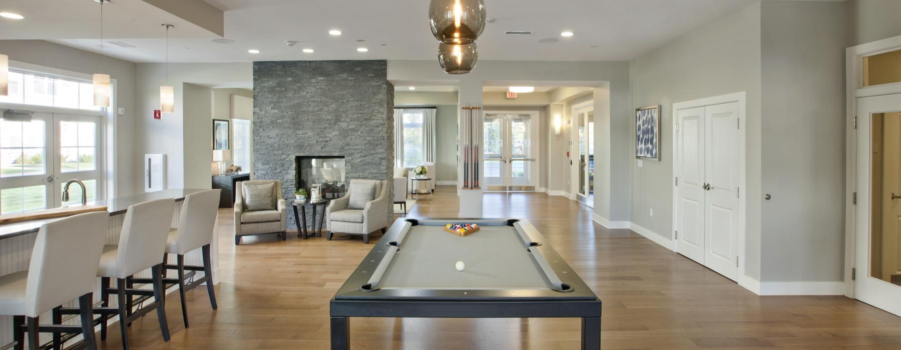 a large room with a table, chairs and a pool table